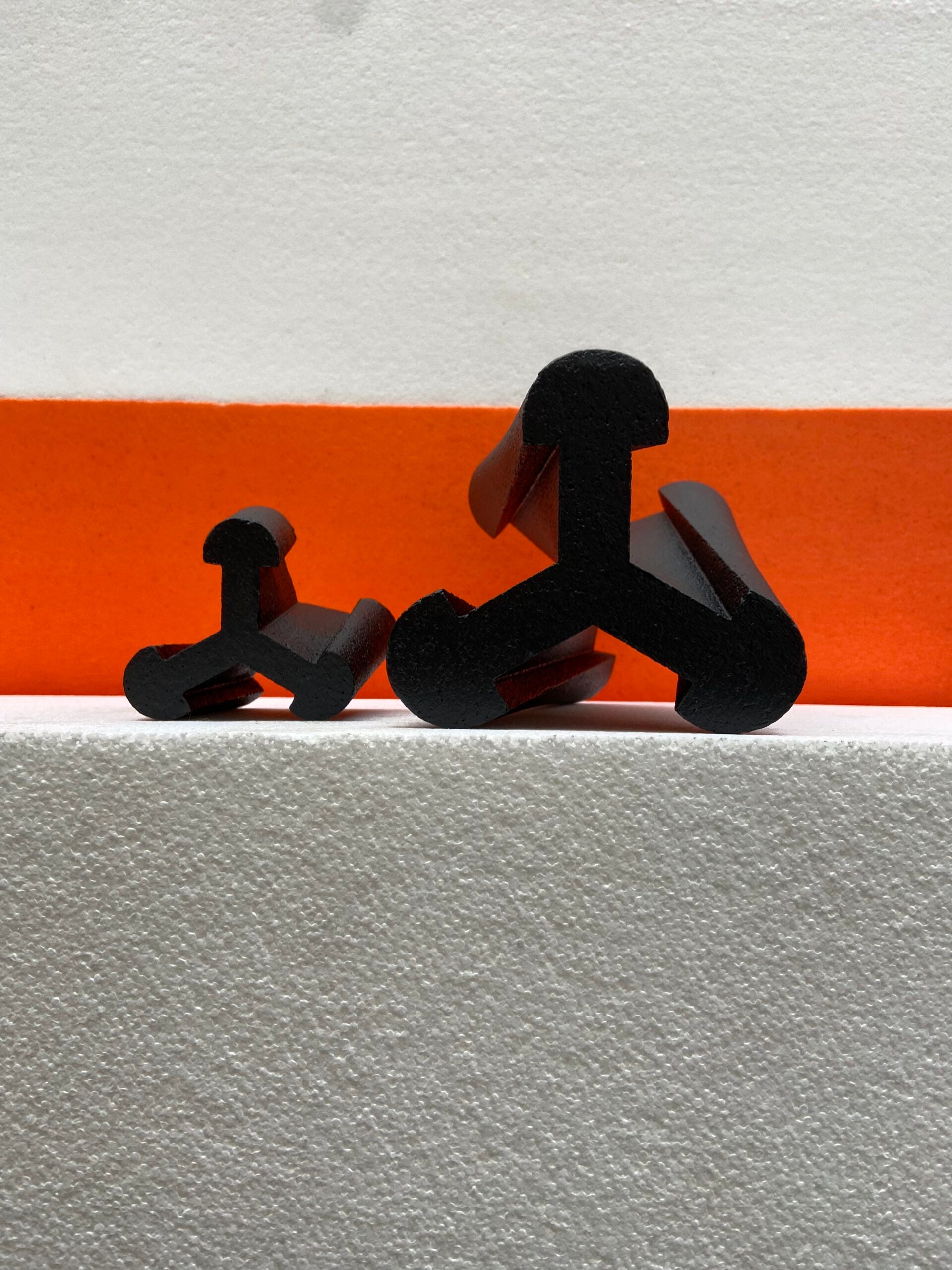 Black dog-shaped objects on a white and orange striped background