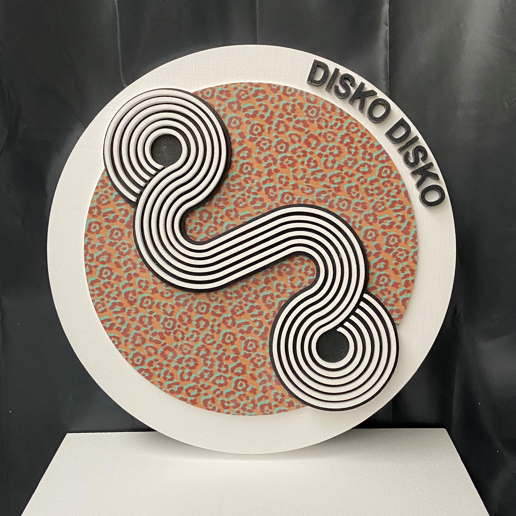 Decorative wall art with 'Disko Disko' branding on a patterned background