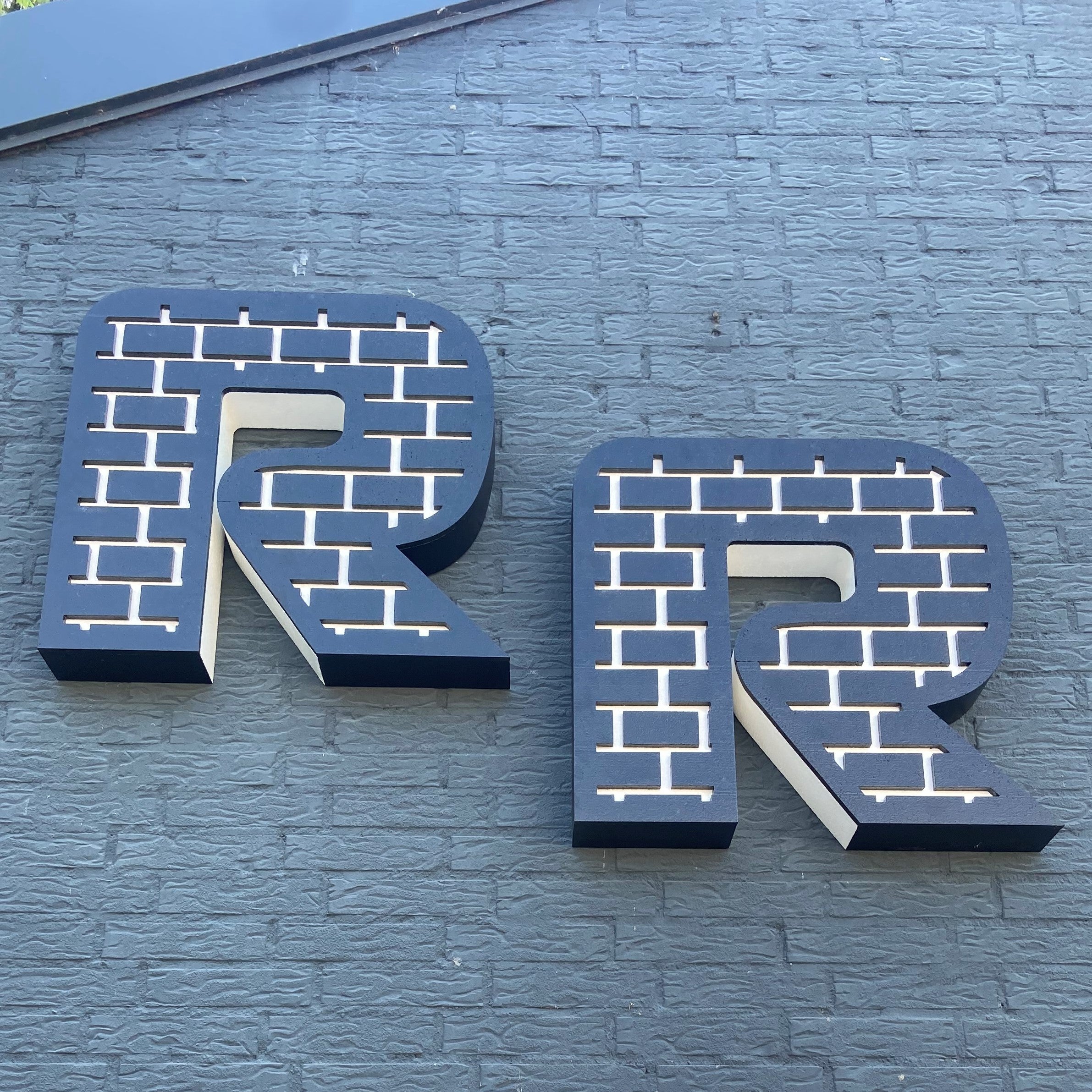 Large 'R' letter on a brick wall